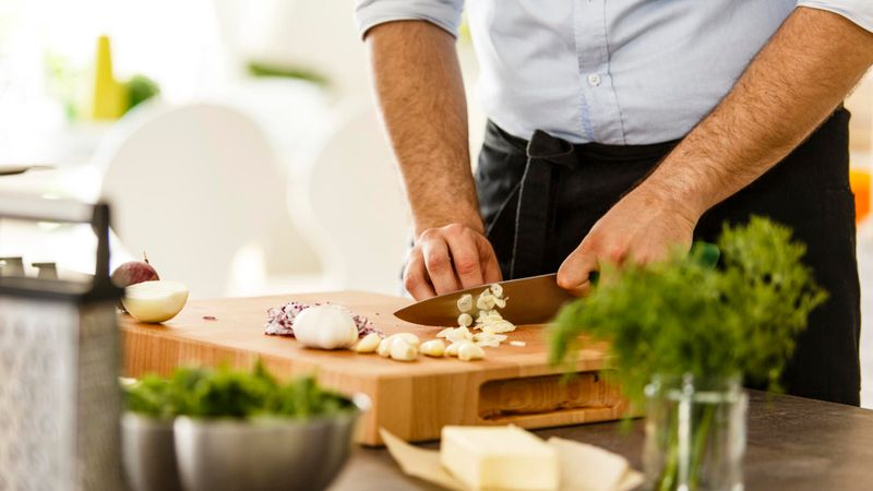 Illustration d'une personne en train de couper de l'ail